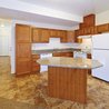 Kitchen with oak cabinets, granite island, and white appliances