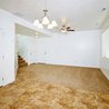 Open great room with ceiling fan and stairs to the entry